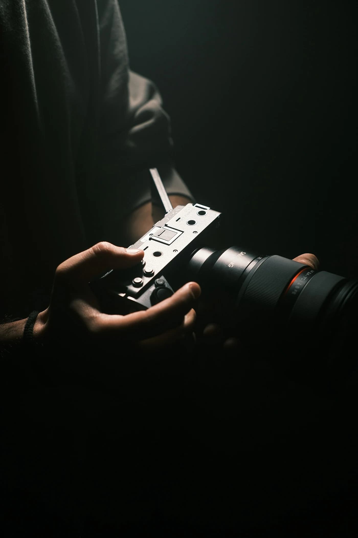 Close-up of a filmmaker holding a cinema camera in soft directional light